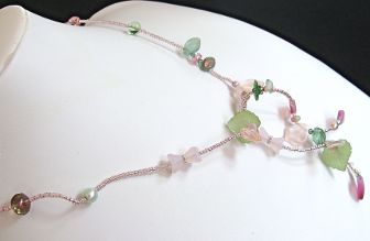 Delicate vine-like tendril ties simply in front at 24 inches.  Composed of Lucite, Czech glass, Swarovski crystal, Vintage glass, fresh water pearls and glass seed beads.