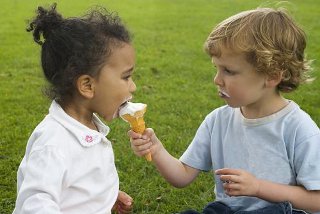 two children sharing an ice cream cone